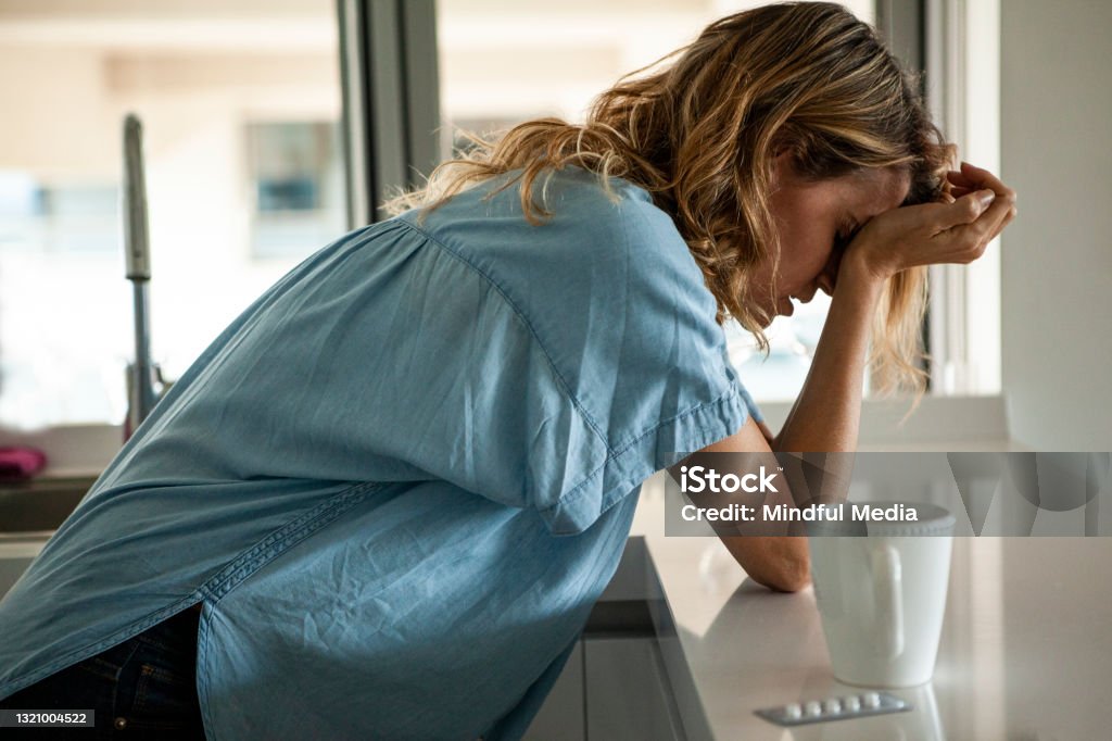 Potrait of stressed woman with head in hands standing indoors during daytime Alexandra Elzesser - Einzelberatung Overath